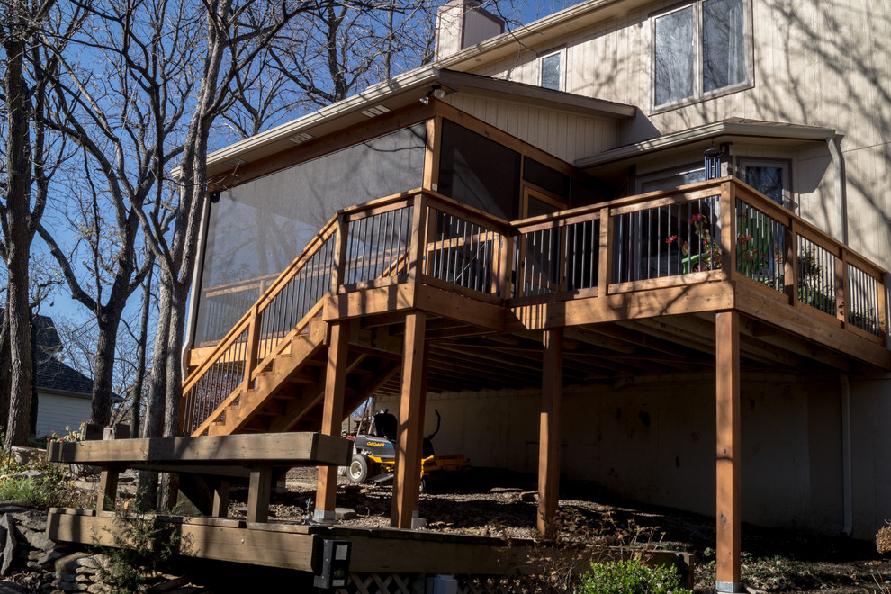 Aménagement d'une grande terrasse arrière craftsman avec une extension de toiture.