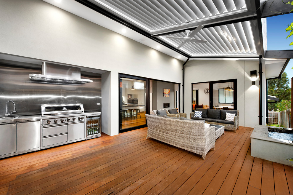 Aménagement d'une grande terrasse latérale contemporaine avec une cuisine d'été et une pergola.