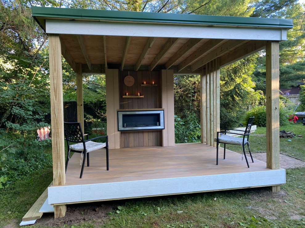 Small minimalist backyard privacy deck photo in Other with a roof extension