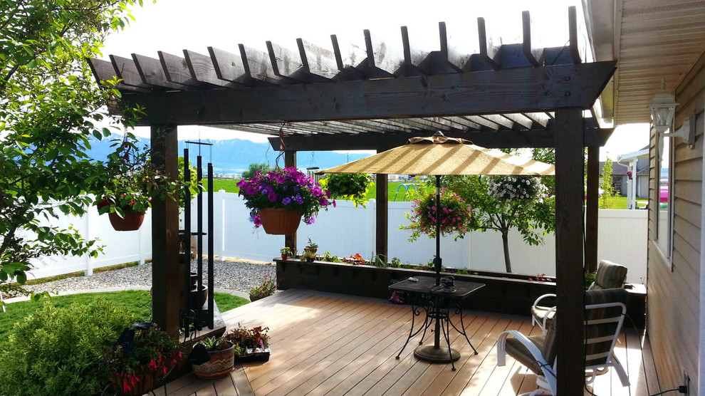 Ejemplo de terraza tradicional de tamaño medio en patio trasero con jardín de macetas y pérgola
