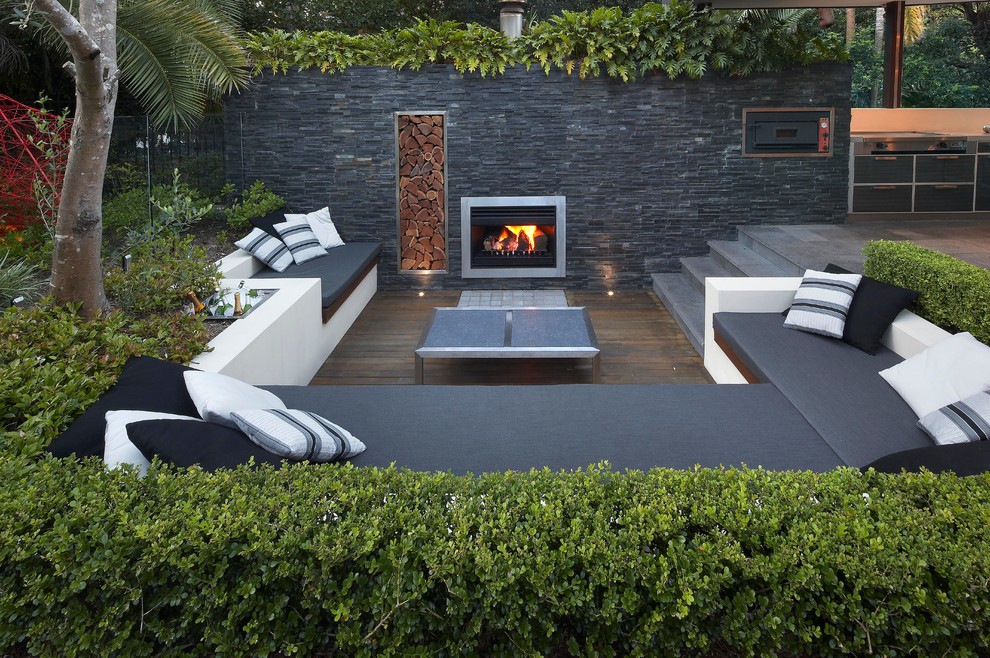 Example of a trendy backyard deck design in Sydney with a fire pit and no cover