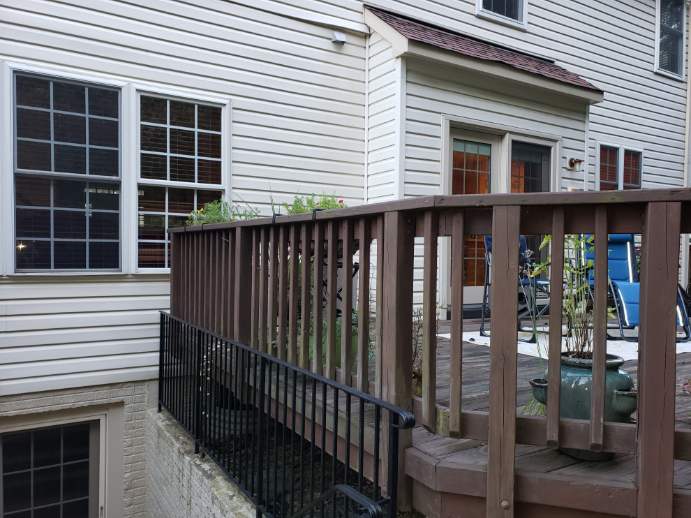 Mid-sized cottage backyard ground level privacy and mixed material railing deck photo in DC Metro with a roof extension