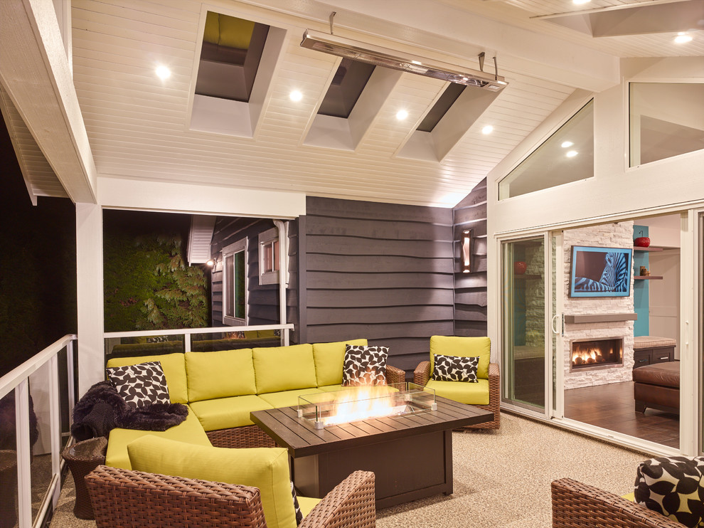 Example of a mid-sized transitional backyard deck design in Vancouver with a fire pit and a roof extension