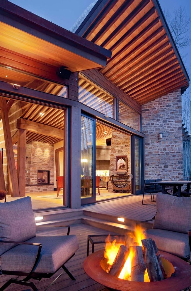 Idée de décoration pour une terrasse design avec un foyer extérieur.