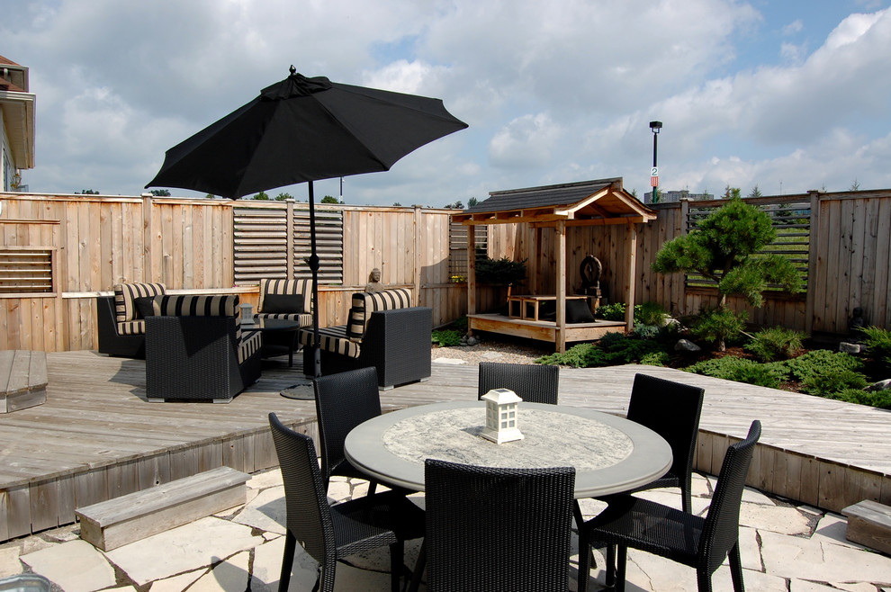 Inspiration for a mid-sized asian backyard deck remodel in Ottawa with a pergola