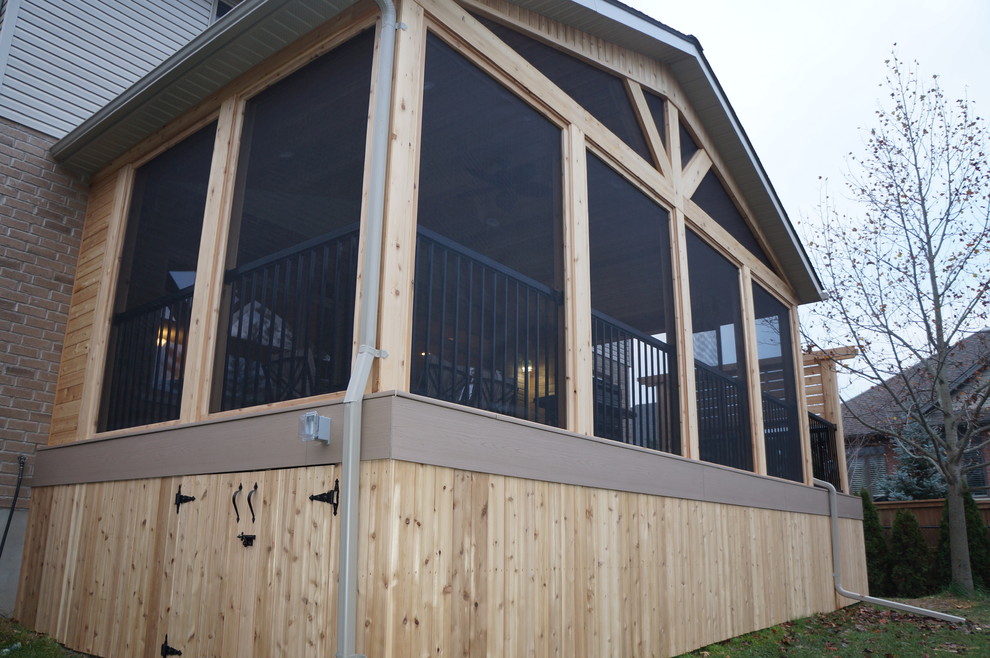 Réalisation d'une grande terrasse arrière craftsman avec une extension de toiture et une cuisine d'été.
