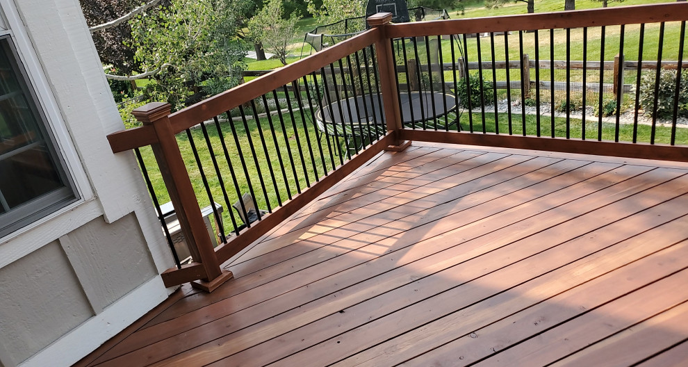 Example of a large mountain style backyard second story metal railing deck design in Denver with no cover