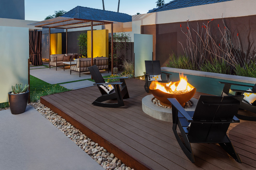Example of a mid-sized minimalist backyard deck design in Phoenix with a fire pit and no cover