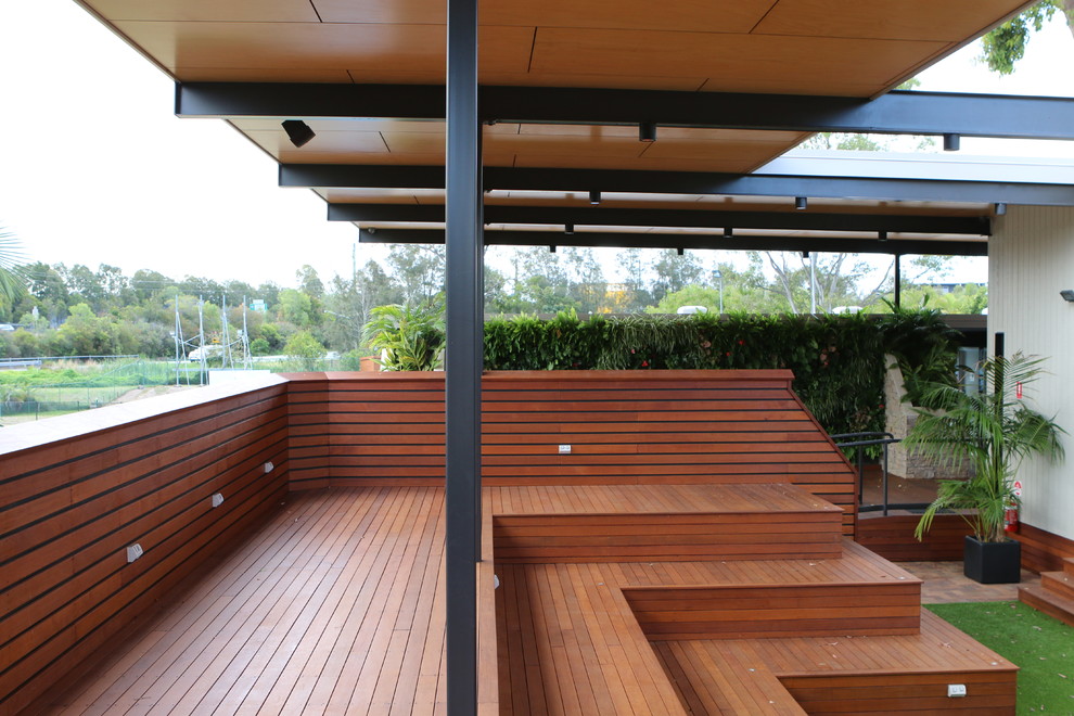 Réalisation d'une terrasse arrière design avec une extension de toiture.