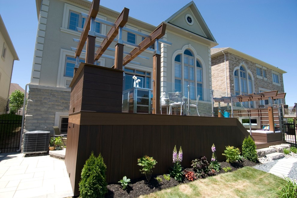 Foto på en stor funkis terrass på baksidan av huset, med utekök och en pergola