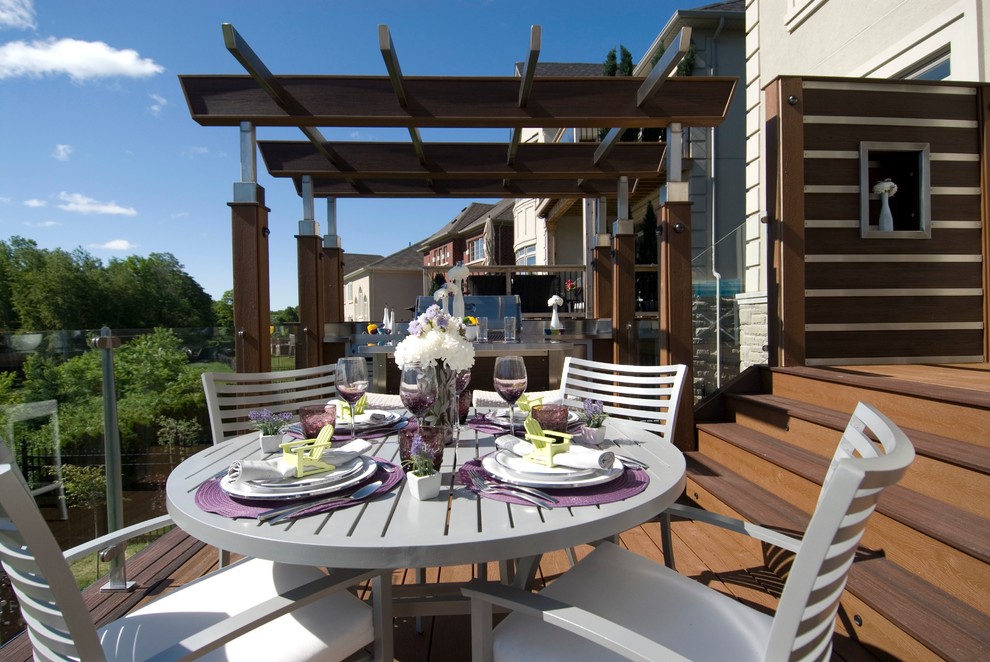 Example of a large trendy backyard outdoor kitchen deck design in Toronto with a pergola