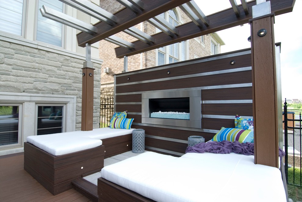 Photo of a large contemporary back terrace in Toronto with a fire feature and a pergola.