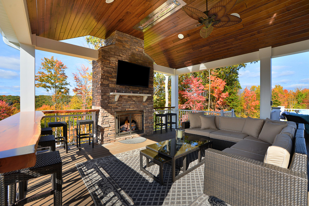 Mid-sized mountain style backyard deck photo in Other with a fire pit and a roof extension