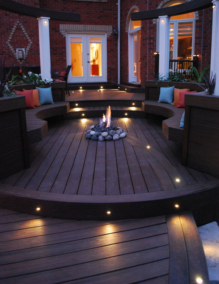 Example of a large trendy backyard deck design in Toronto with a fire pit and no cover
