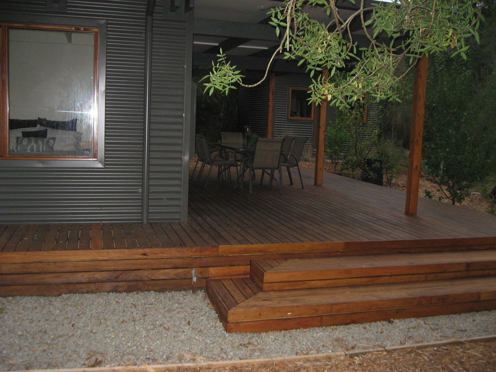 Cette image montre une petite terrasse latérale design avec une extension de toiture.