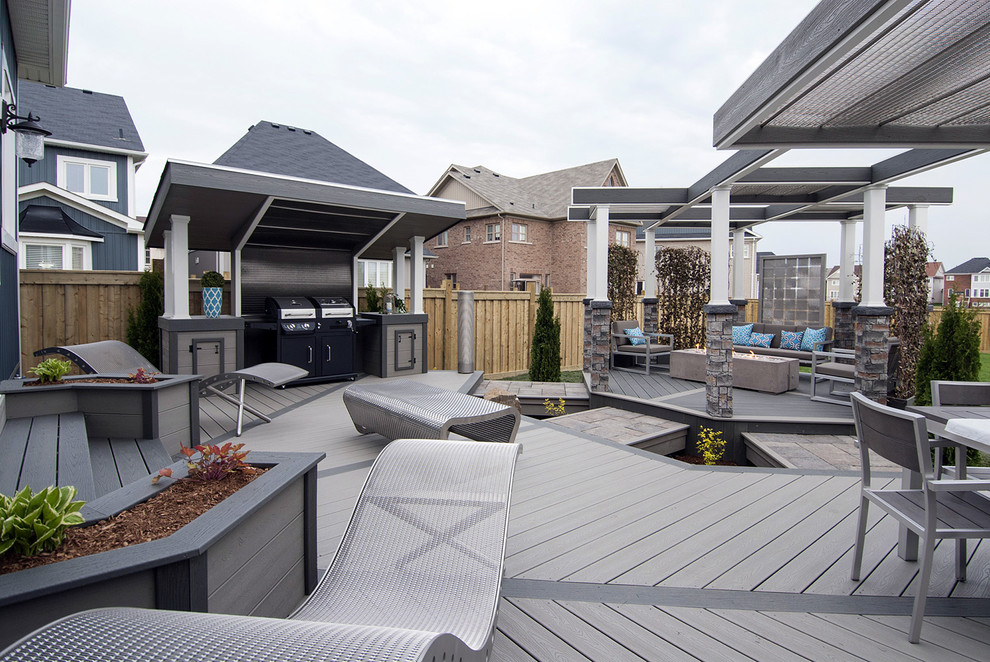 This is an example of a medium sized urban back terrace in Toronto with a fire feature and a pergola.