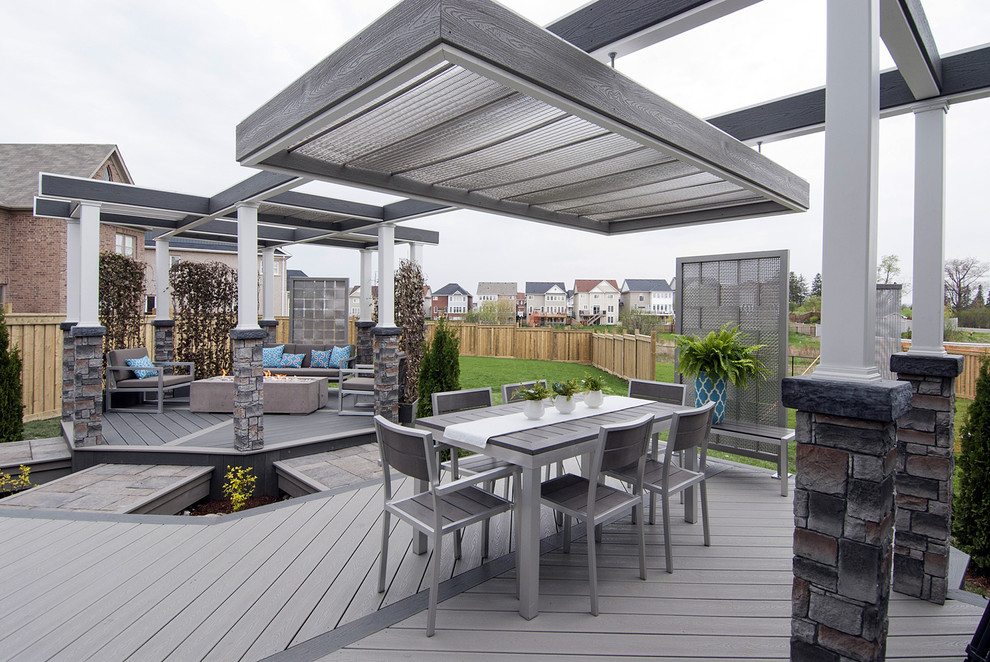 This is an example of a medium sized industrial back terrace in Toronto with a fire feature and a pergola.