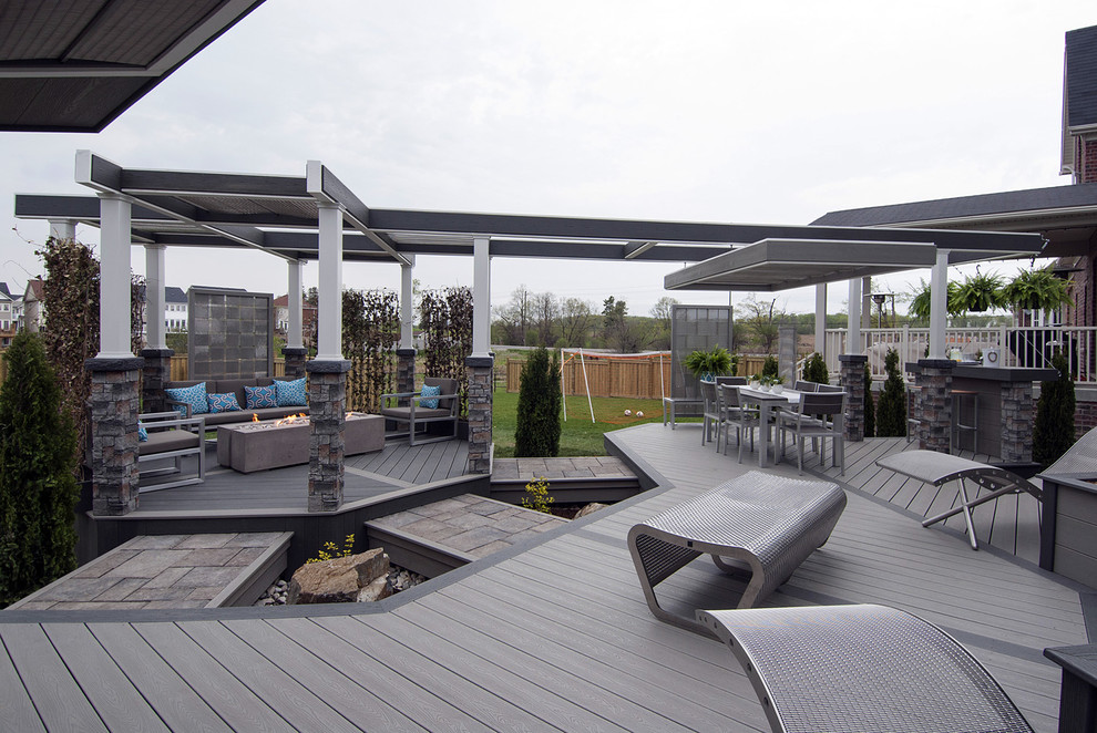 Medium sized industrial back terrace in Toronto with a fire feature and a pergola.