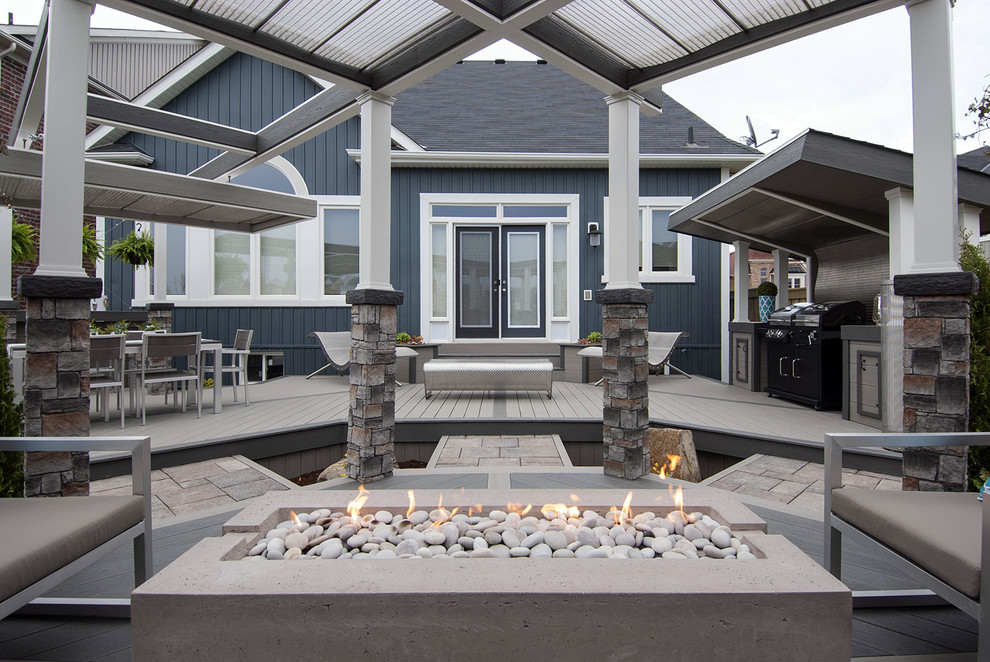 Design ideas for a medium sized urban back terrace in Toronto with a fire feature and a pergola.