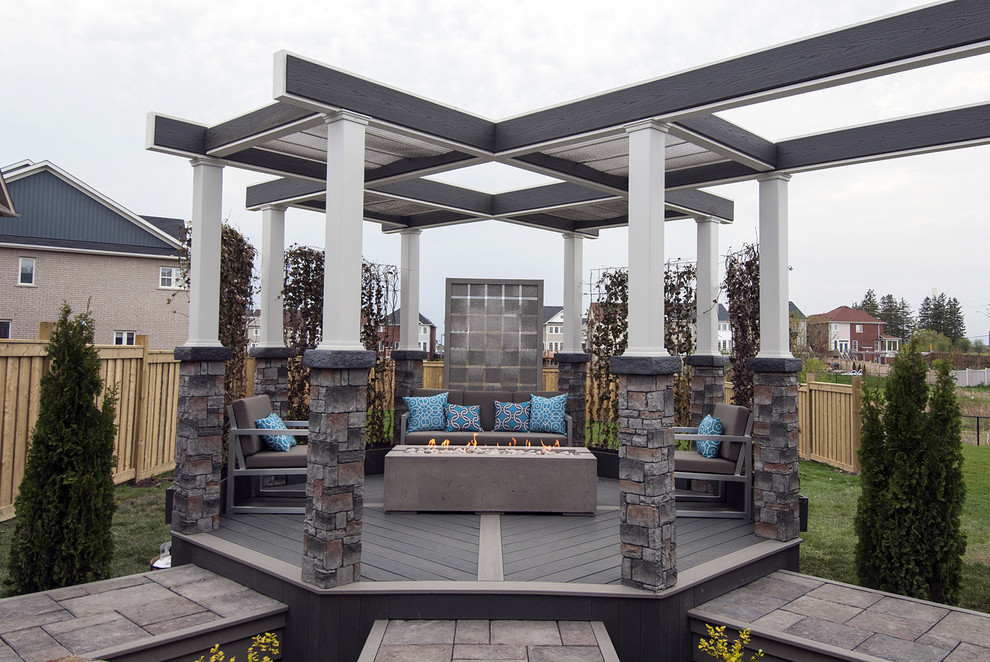 Photo of a medium sized urban back terrace in Toronto with a fire feature and a pergola.