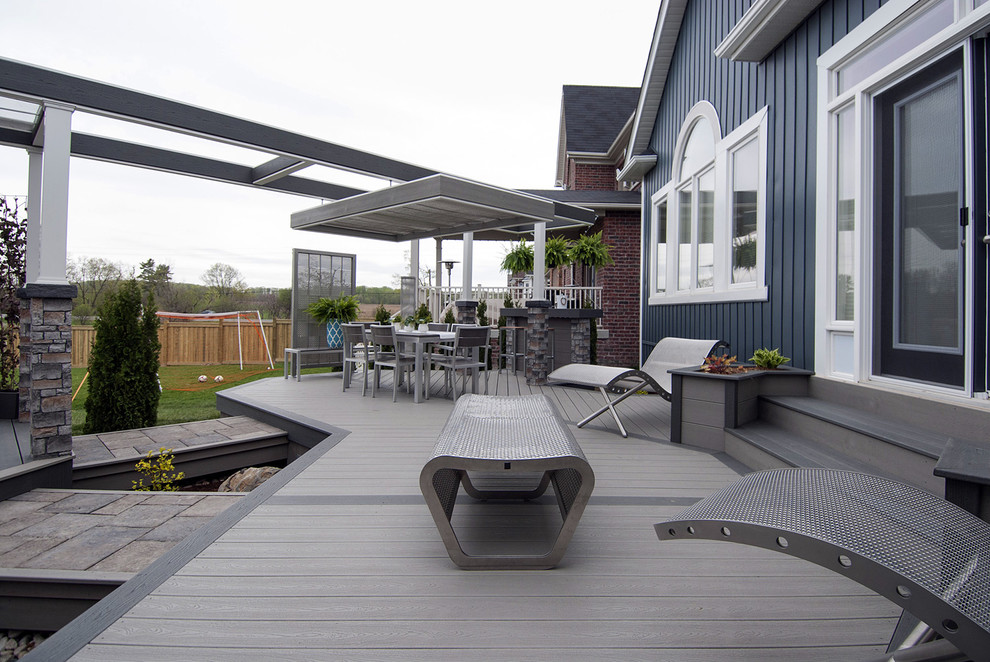 Medium sized urban back terrace in Toronto with a fire feature and a pergola.