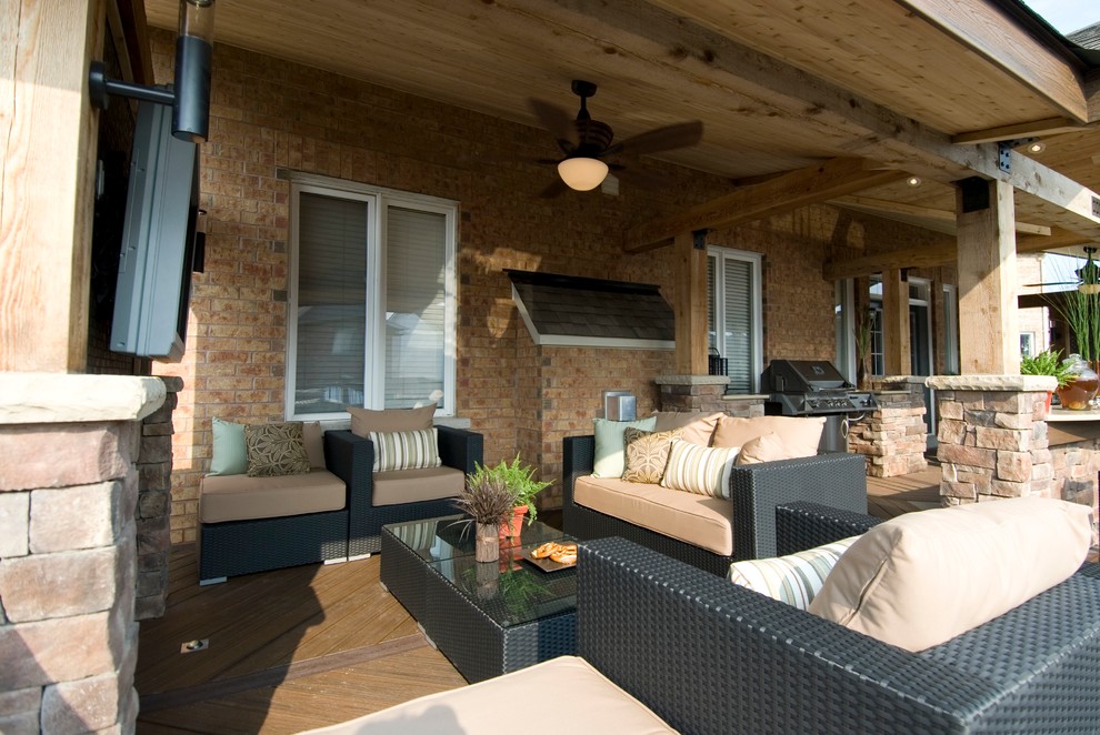 Example of a large classic backyard outdoor kitchen deck design in Toronto with a roof extension