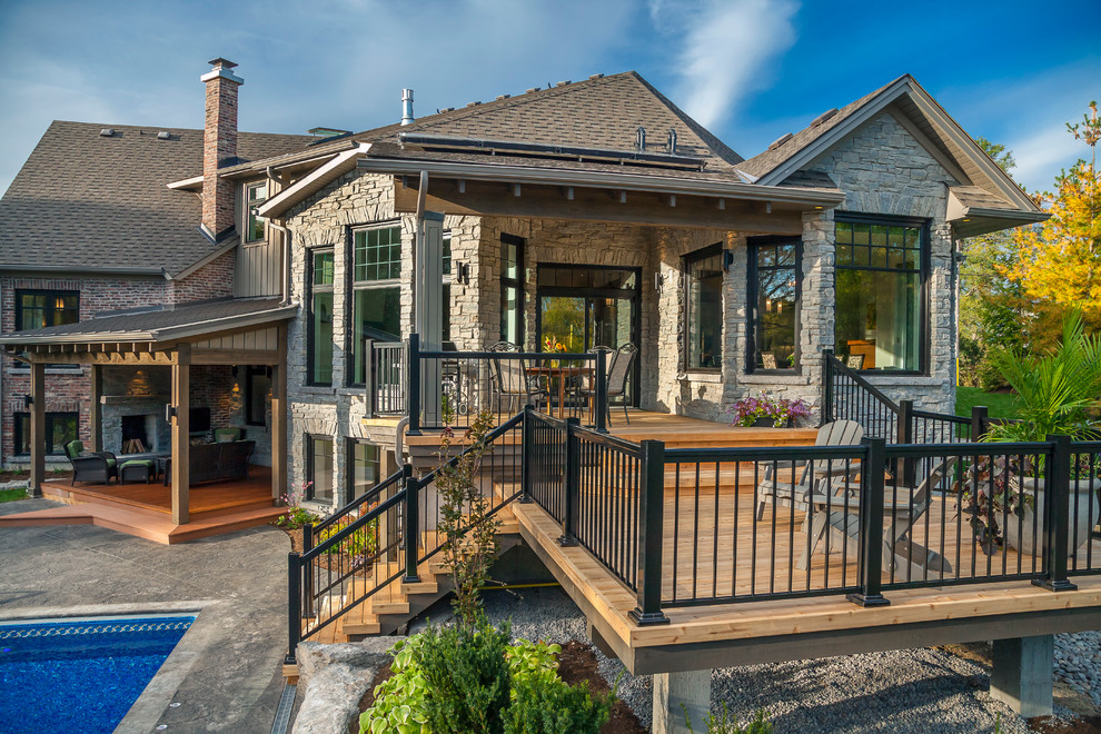 Photo of a large traditional back terrace in Toronto with a fire feature and a roof extension.