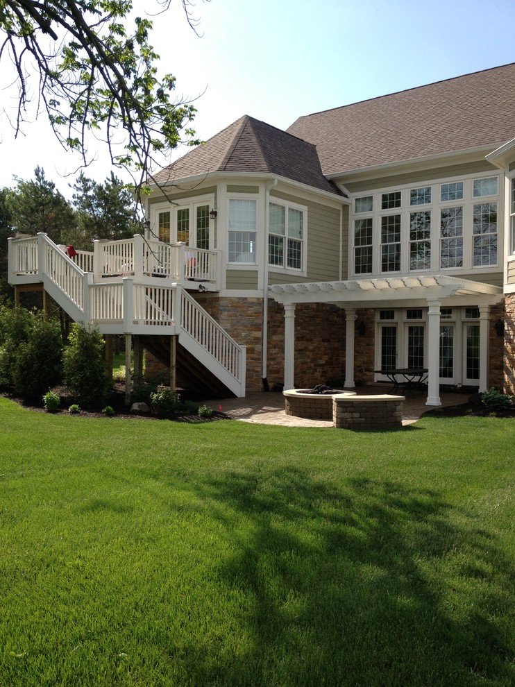 Diseño de terraza de estilo americano de tamaño medio en patio trasero con brasero y pérgola
