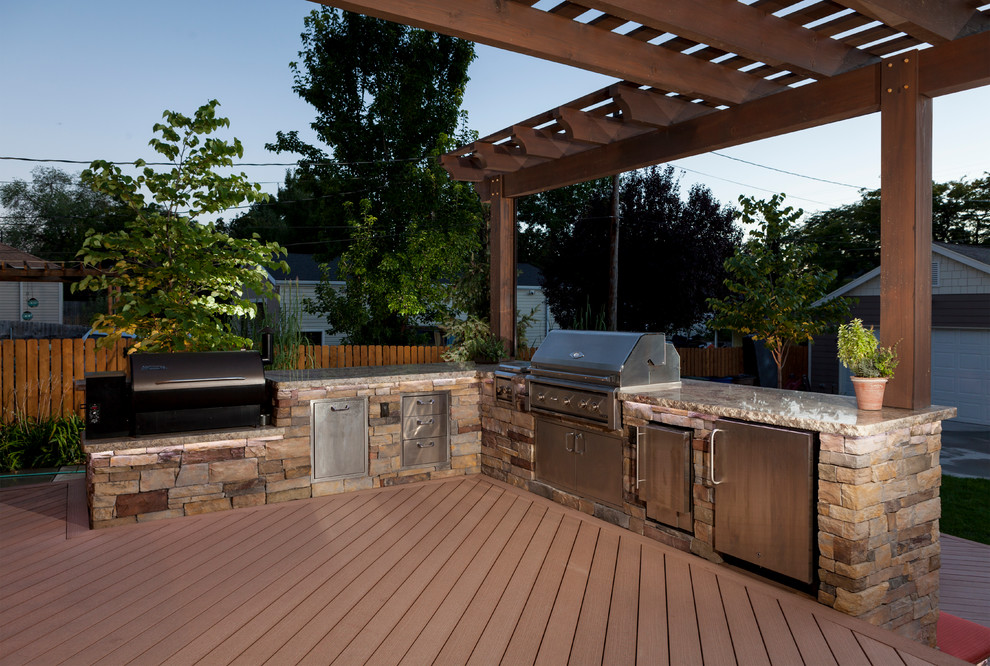 Diseño de terraza moderna en patio trasero con cocina exterior y pérgola