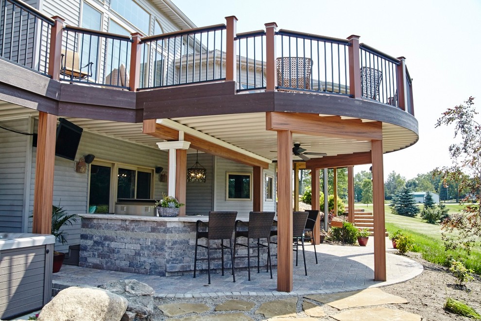 Huge eclectic backyard deck photo in Other with a fire pit