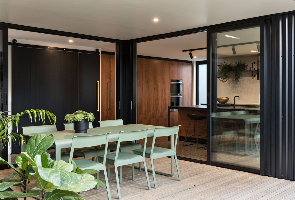 This is an example of a contemporary ground level terrace in Auckland with a roof extension.