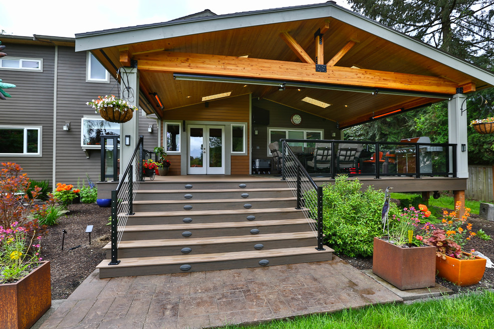 Cette image montre une grande terrasse arrière minimaliste avec une cuisine d'été et une extension de toiture.