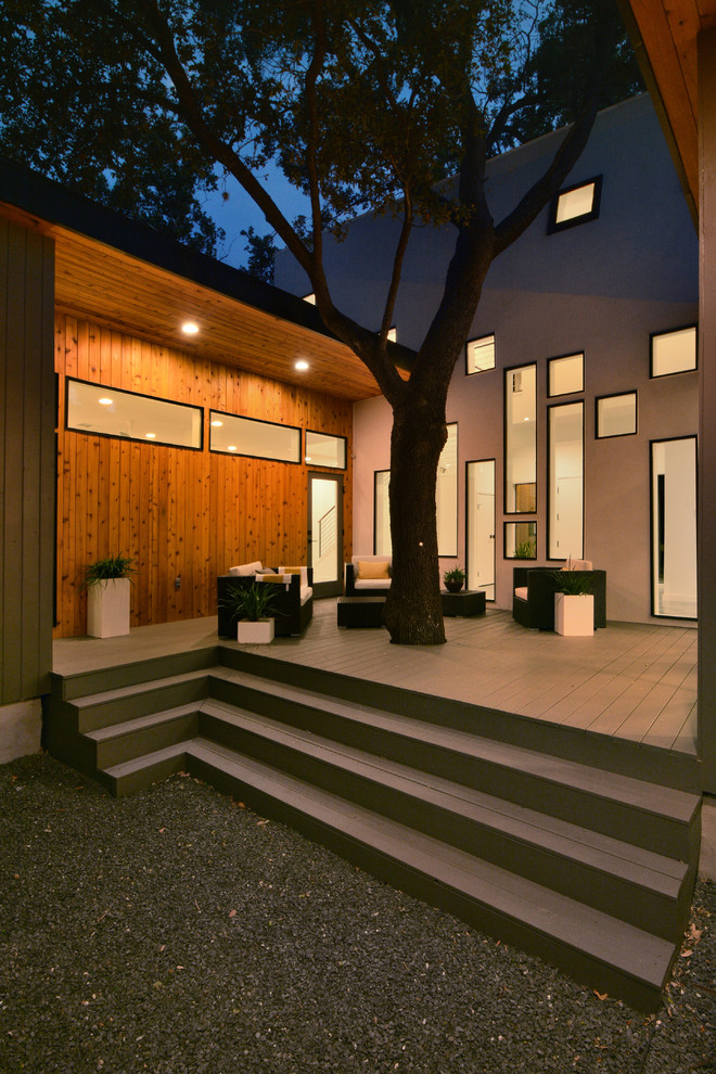 Ispirazione per una terrazza moderna di medie dimensioni e dietro casa con un tetto a sbalzo