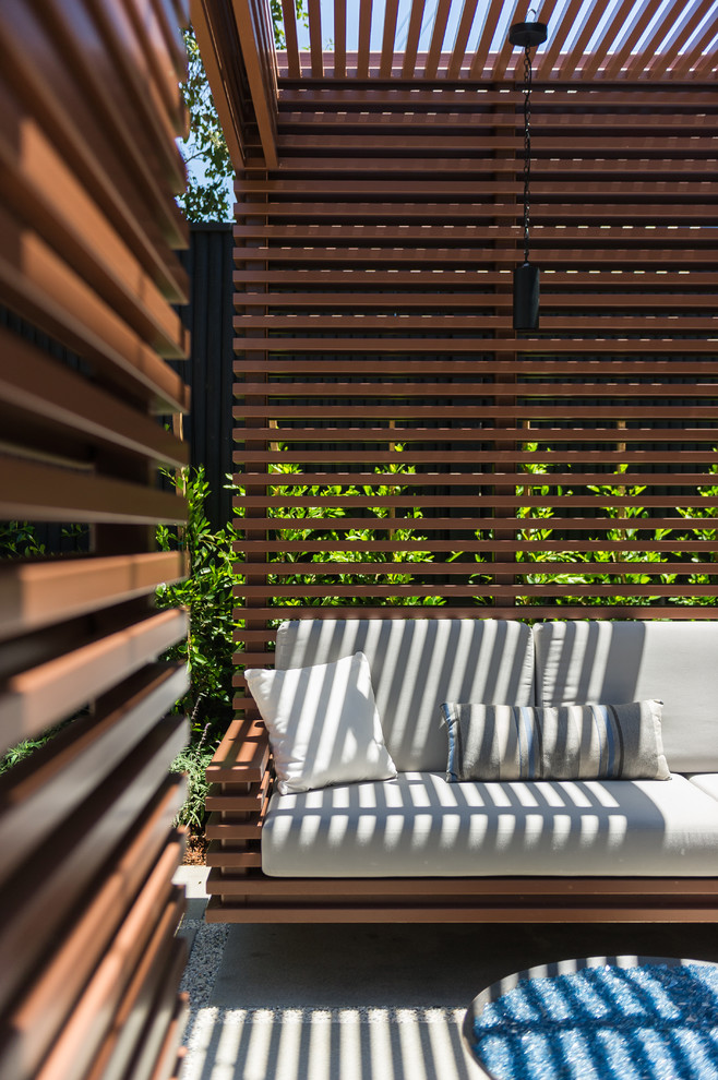Imagen de terraza contemporánea pequeña en patio trasero con brasero y pérgola