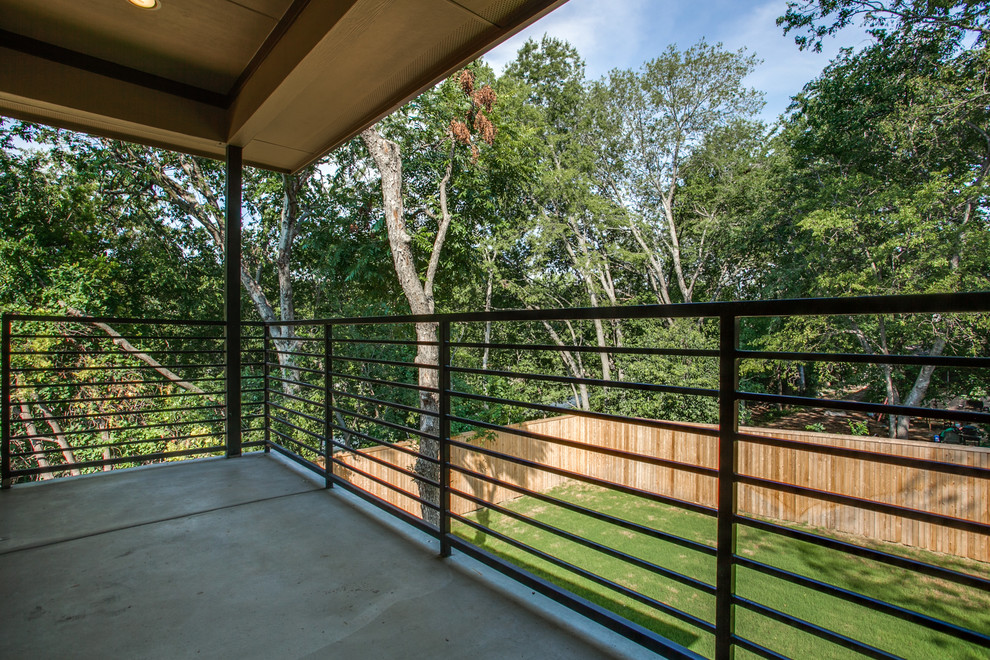 This is an example of a medium sized modern back terrace in Dallas with a roof extension.