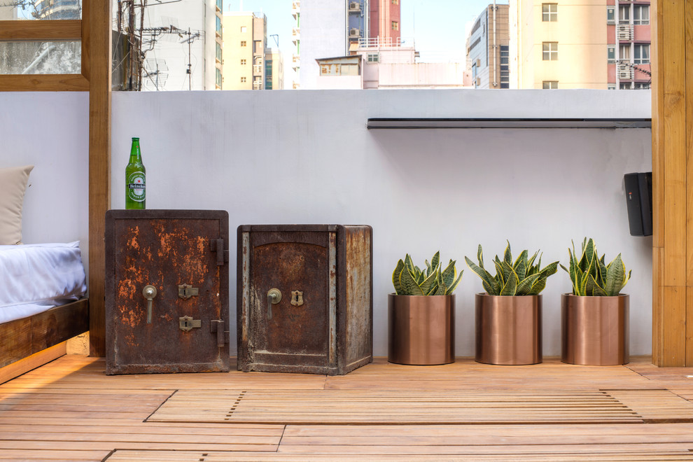 Example of a mid-sized urban rooftop deck design in Hong Kong with a pergola