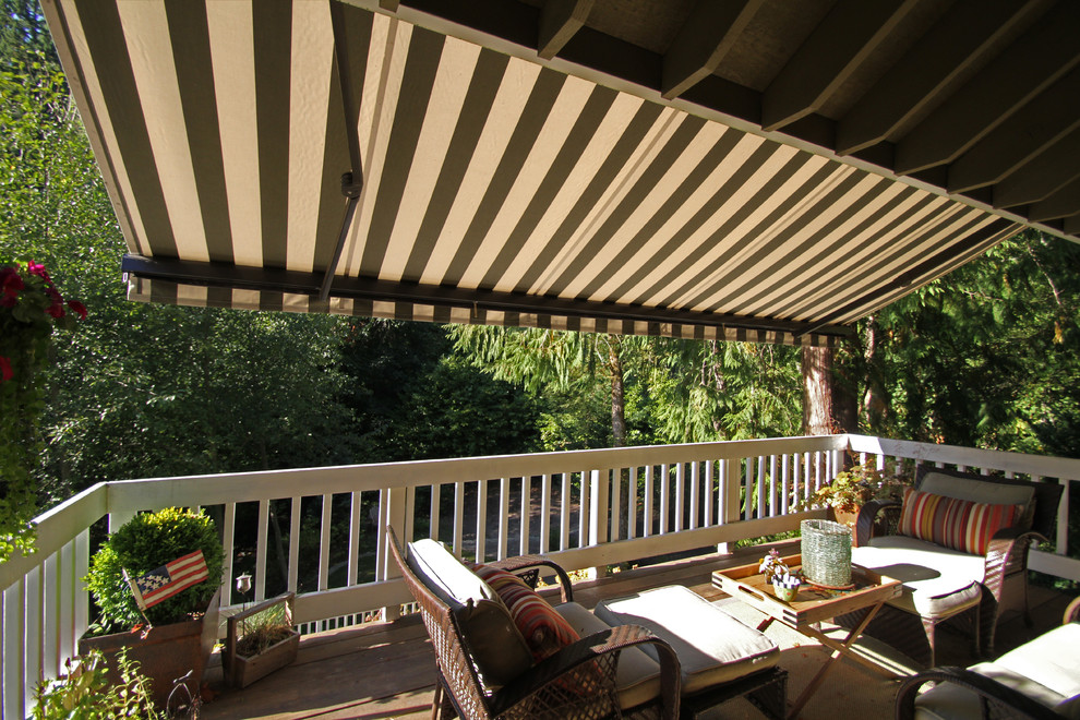 Example of a mid-sized arts and crafts backyard deck design in Portland with an awning