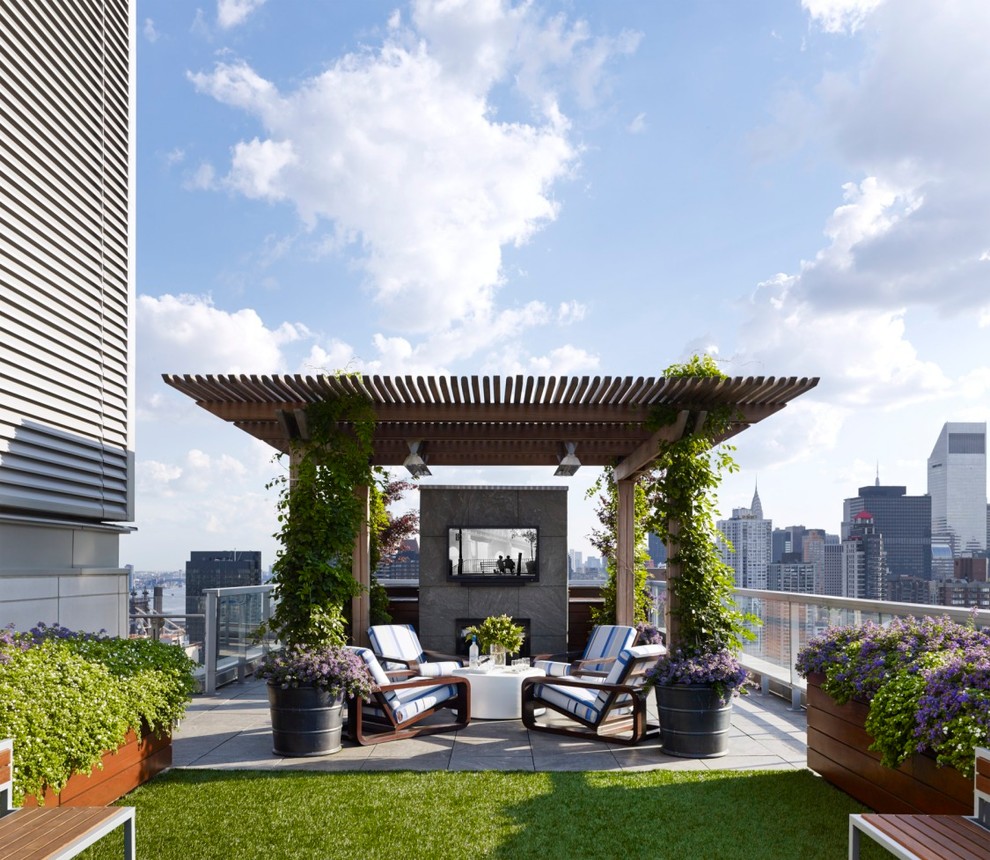 Aménagement d'un toit terrasse sur le toit contemporain avec un foyer extérieur et une pergola.