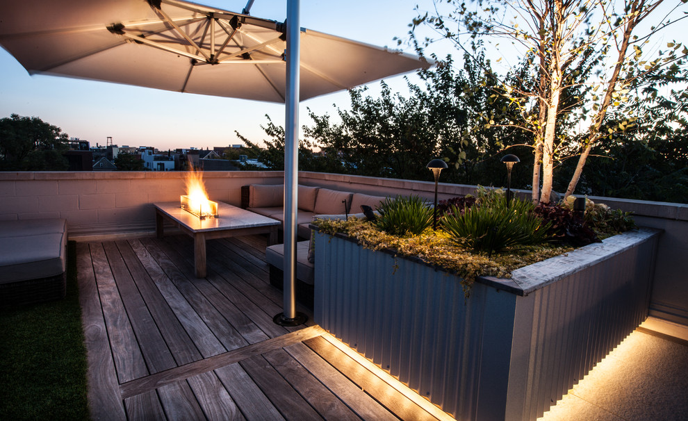 Ispirazione per una terrazza industriale di medie dimensioni e sul tetto con un giardino in vaso e un parasole