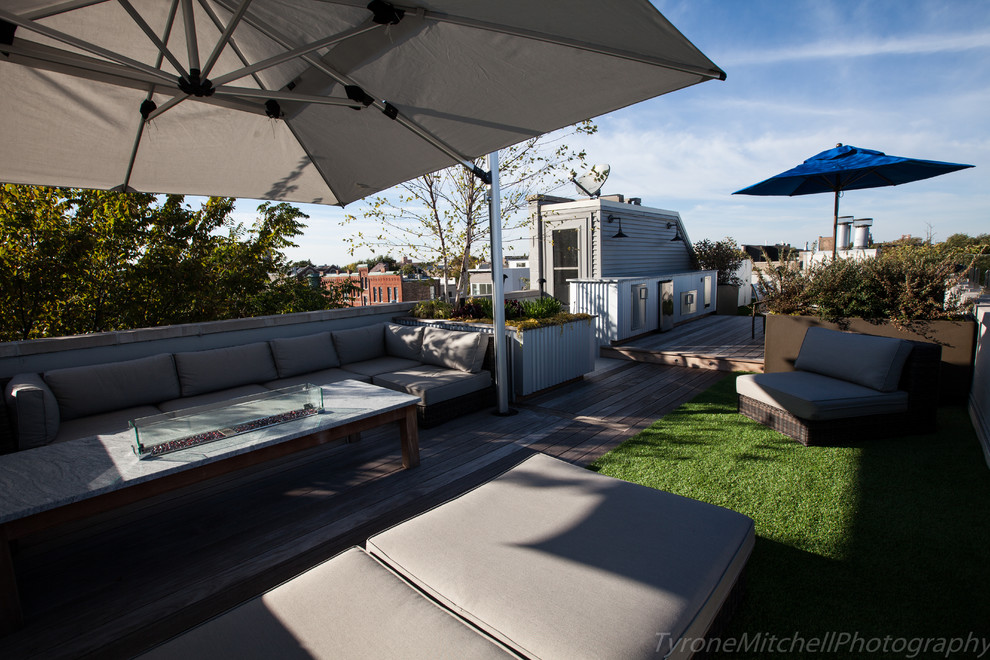 Example of a mid-sized urban rooftop deck design in Chicago with a fire pit and an awning