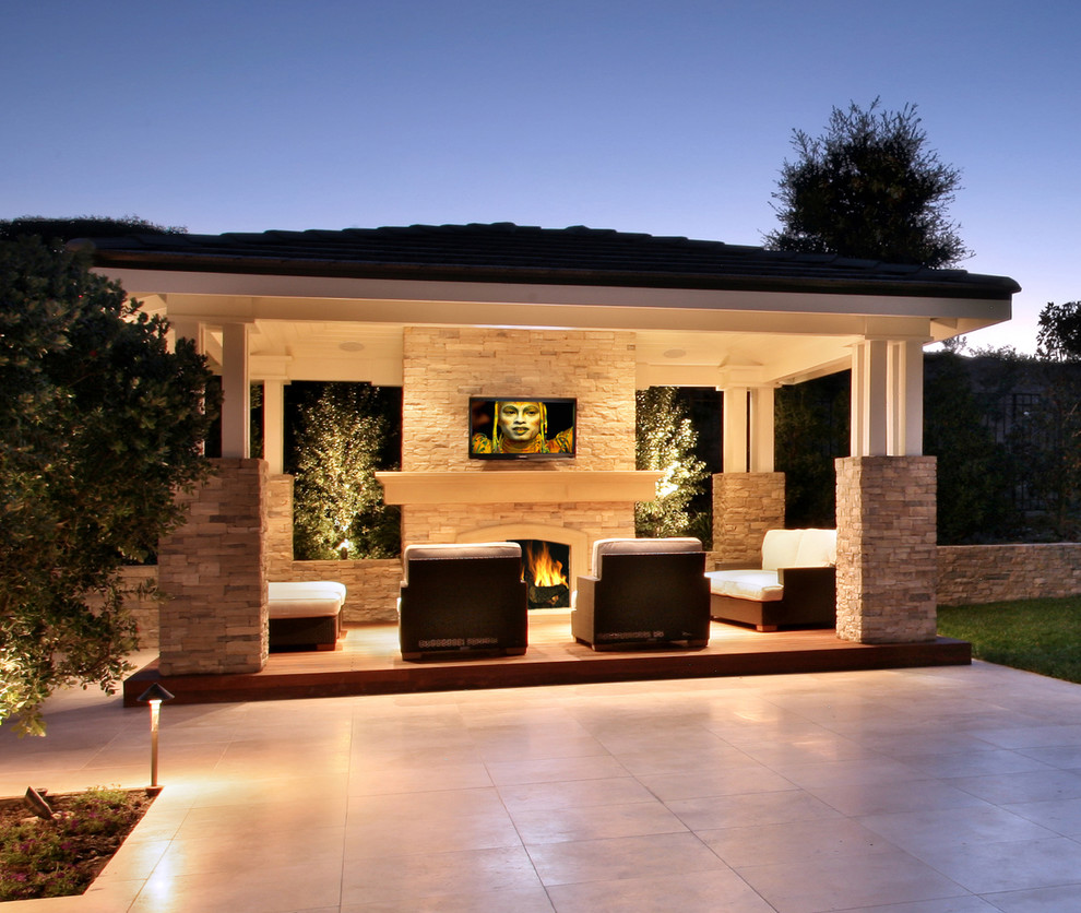 Modelo de terraza mediterránea de tamaño medio en patio trasero con iluminación