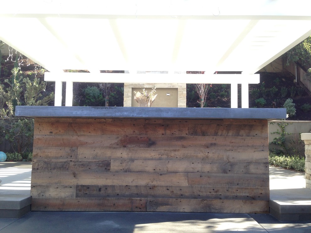 На фото: пергола на террасе среднего размера на заднем дворе в стиле модернизм с местом для костра