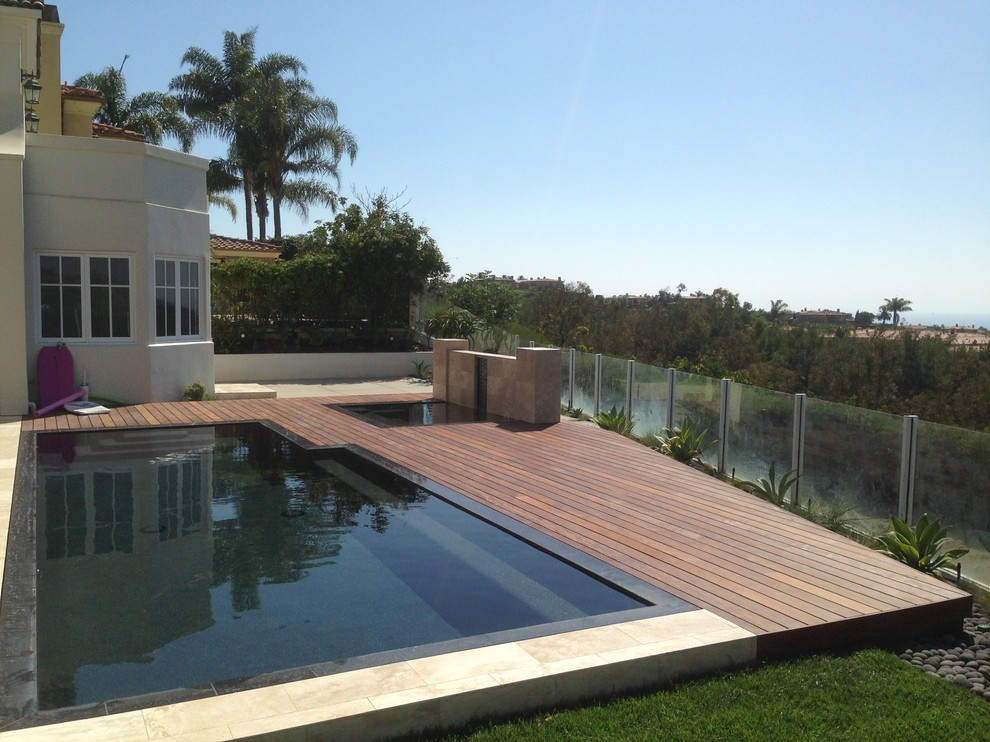 Réalisation d'une grande terrasse arrière minimaliste avec un point d'eau.
