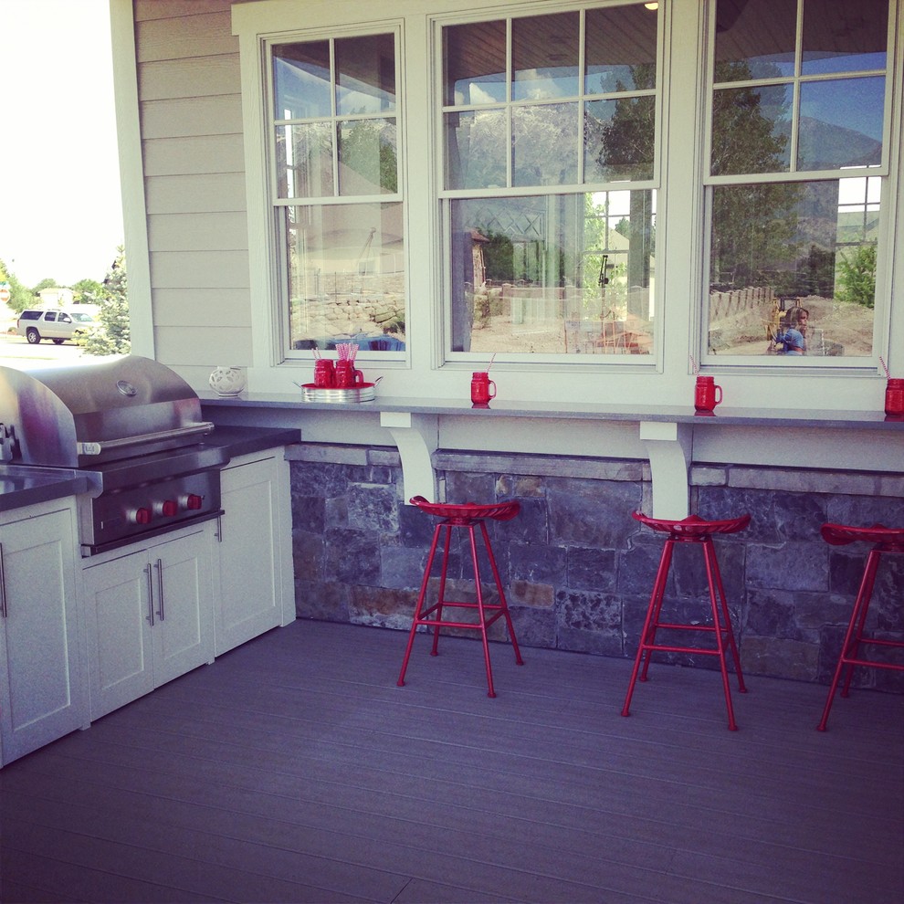 Large country back terrace in Salt Lake City with an outdoor kitchen and a roof extension.