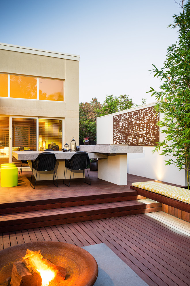 На фото: терраса на заднем дворе в современном стиле с местом для костра без защиты от солнца с