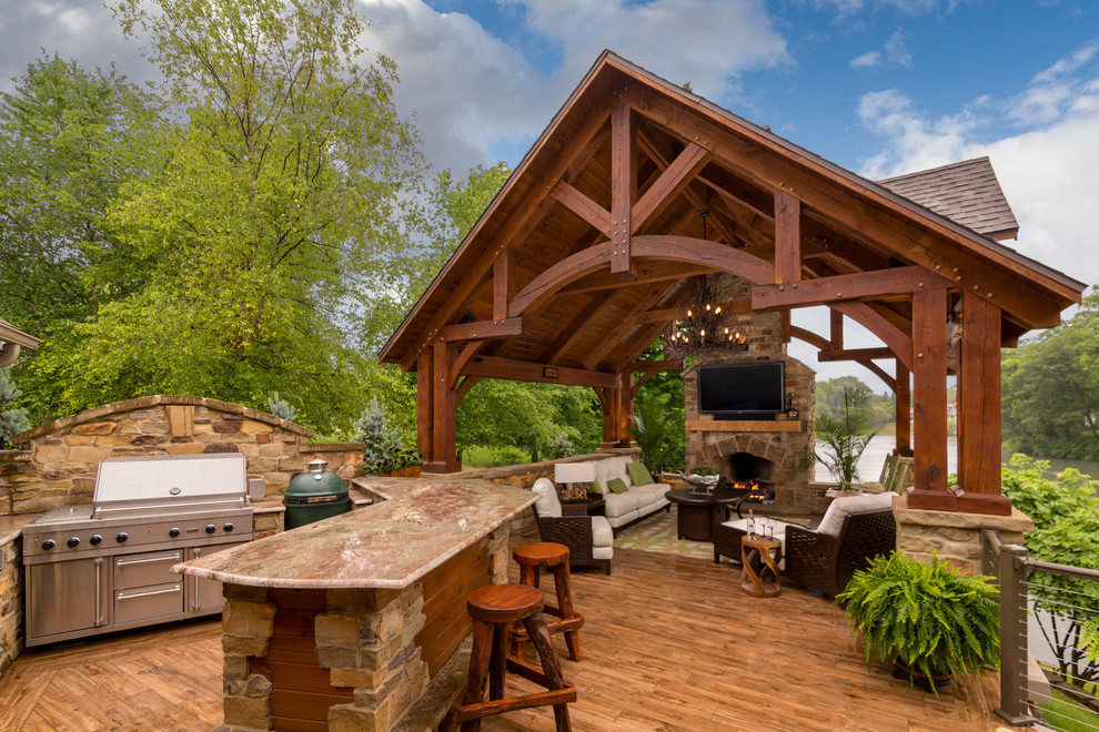 Example of a mountain style backyard deck design in Cleveland with a pergola