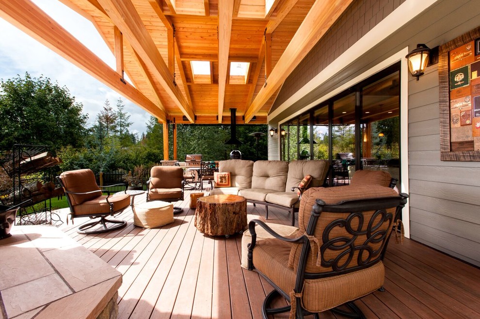 Exemple d'une grande terrasse arrière craftsman avec une cuisine d'été et une extension de toiture.