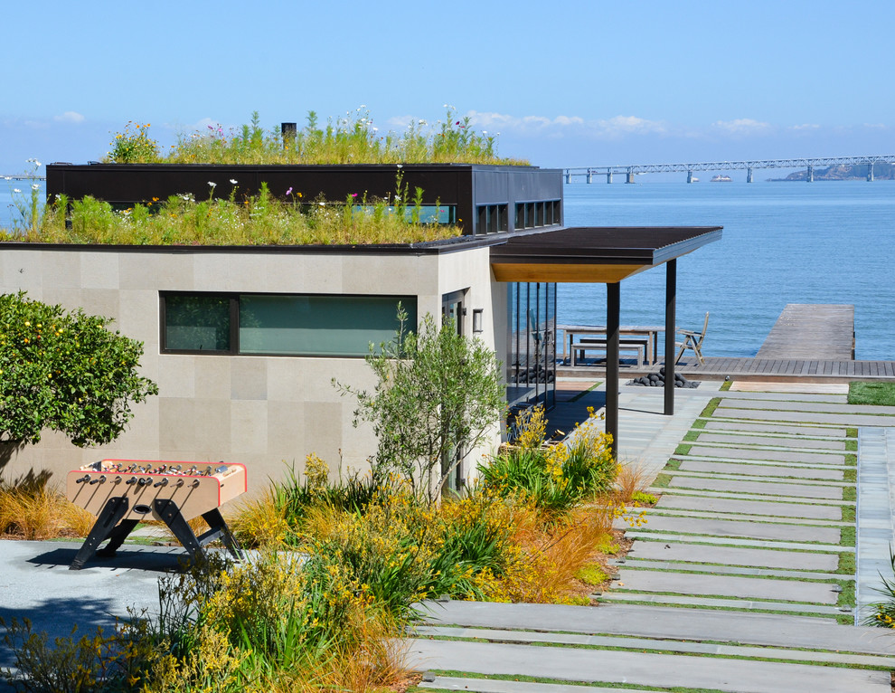 Inspiration for a large industrial side yard water fountain deck remodel in San Francisco with a roof extension
