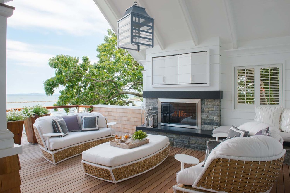 Idée de décoration pour une terrasse arrière marine de taille moyenne avec un foyer extérieur et une extension de toiture.