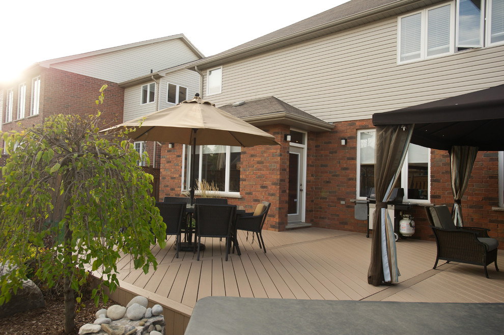 This is an example of a medium sized modern back terrace in Toronto with a pergola.